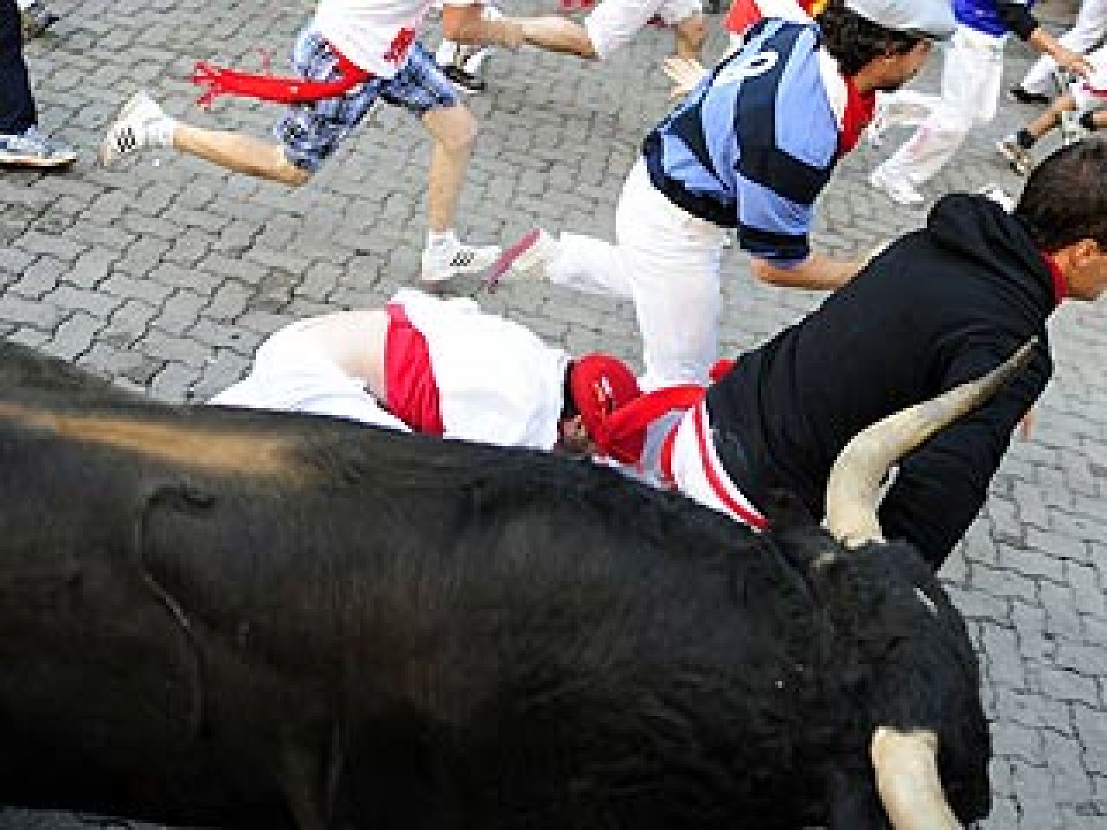 l toro tropieza con varios mozos en Estafeta