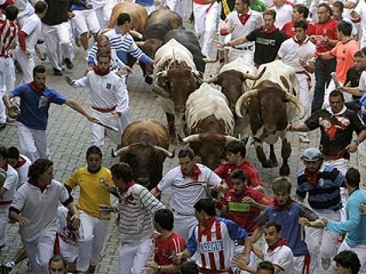 San Fermín - La carrera de un mozo con camisa blanca y verde