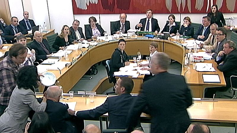 Asalto a Rupert Murdoch durante su comparencencia en el Parlamento británico. Aún se desconoce la identidad de la persona que, al parecer, le ha lanzado una tarta. 