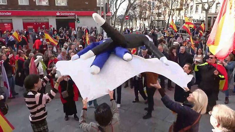 Decenas de personas mantean muñecos de Sánchez y Puigdemont en Ferraz
