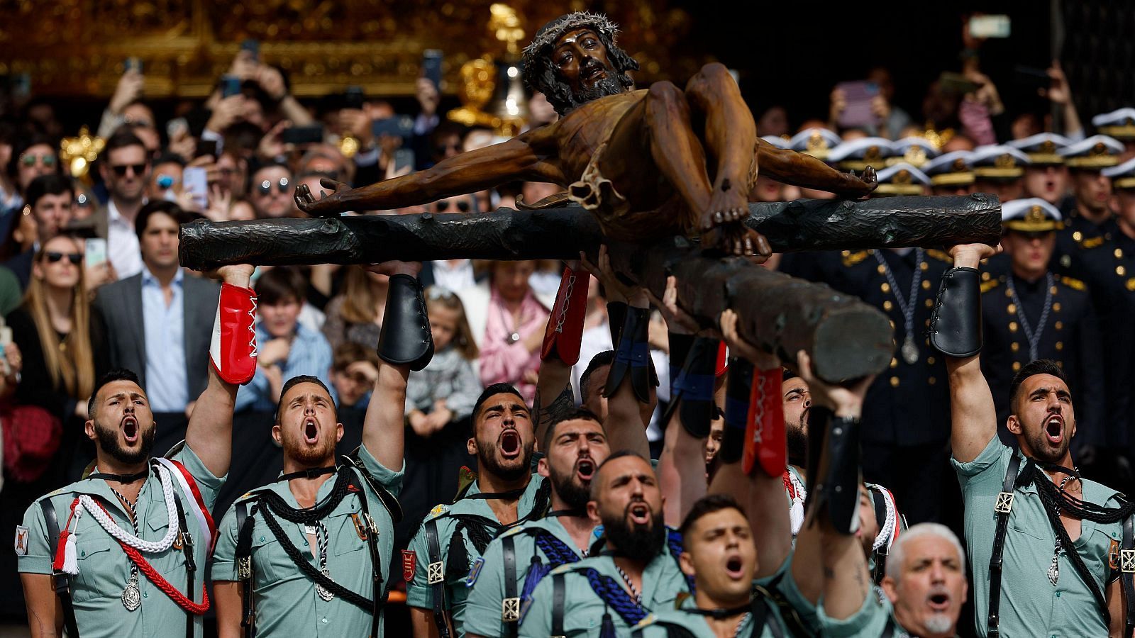 Malagueños y turistas acompañan a la Legión en el traslado del Cristo de Mena este Jueves Santo