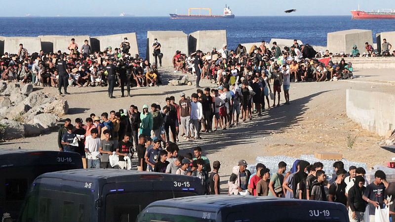 Inicio del reparto de alimentos por parte de miembros de Cruz Roja a los migrantes en la playa del Trampolín