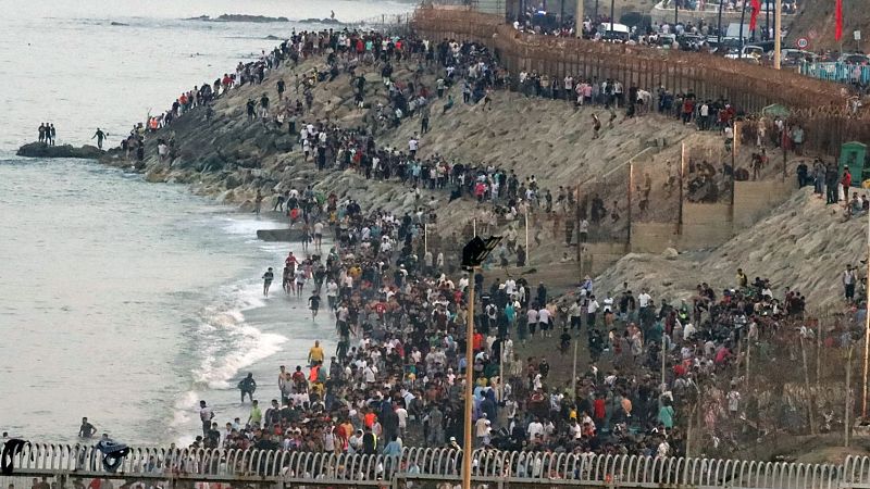 Multitud de personas en la parte marroquí de la playa del Tarajal para intentar acceder a Ceuta el 30 de julio de 2026