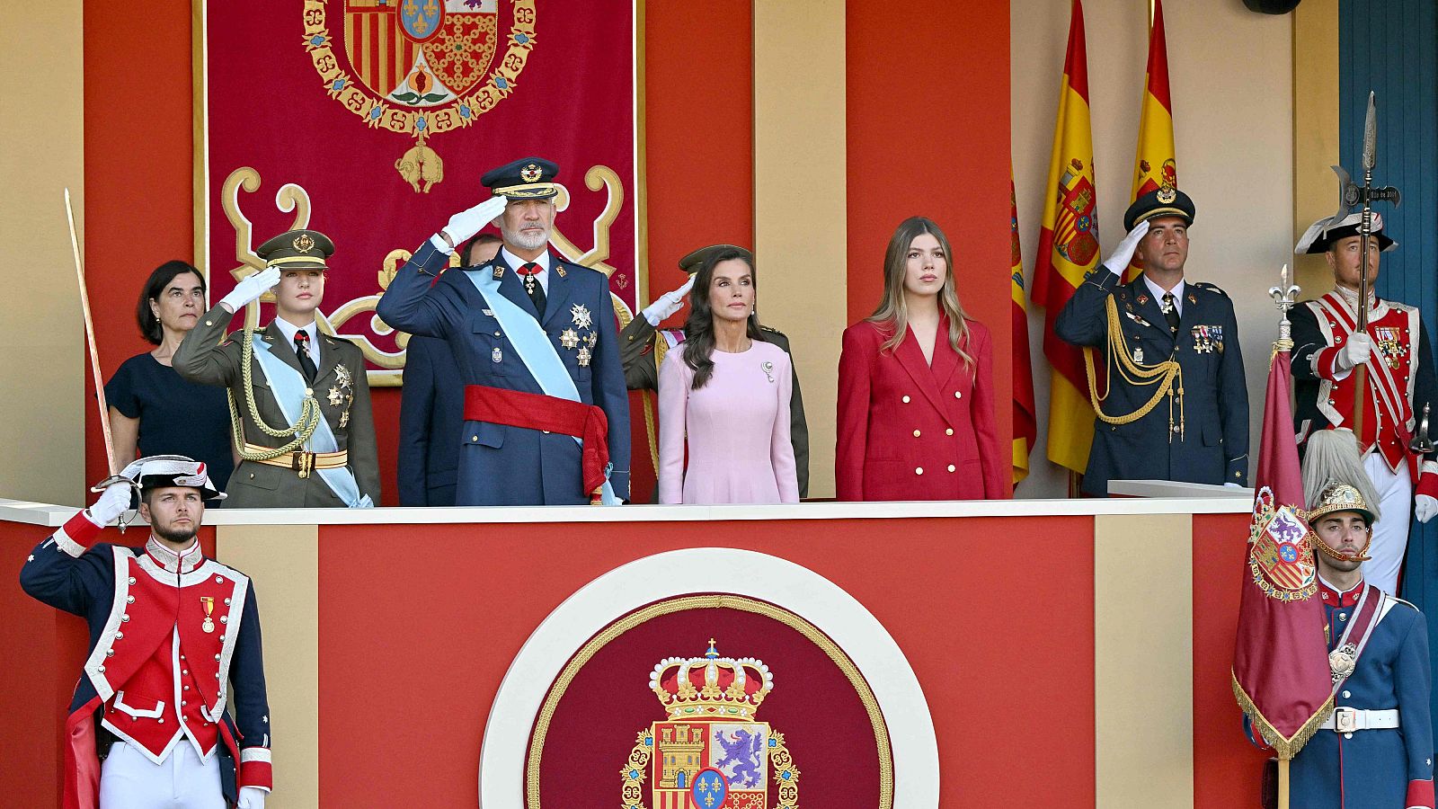 La Familia Real española en la tribuna presidencial durante un acto solemne, con el Rey Felipe VI y la Princesa Leonor realizando el saludo militar.