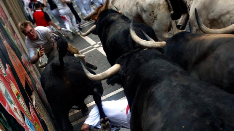 Un astado engancha a un mozo de la camiseta y le golpea contra un muro