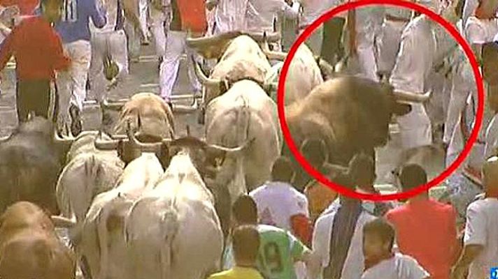 San Fermín - Un toro castaño golpea a un corredor en la espalda