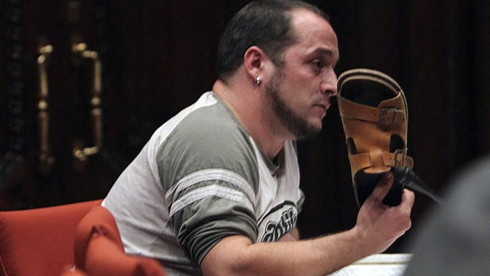 Un diputado de CUP esgrime una sandalia ante Rato como muestra de desprecio