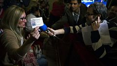 Una agraciada con el número 00000 celebra el premio en el salón de la lotería de Navidad