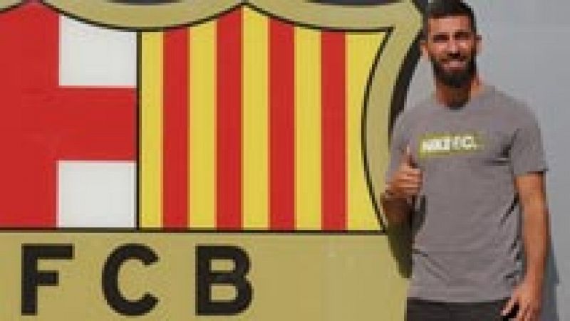 Arda Turan posa junto al escudo del Barça