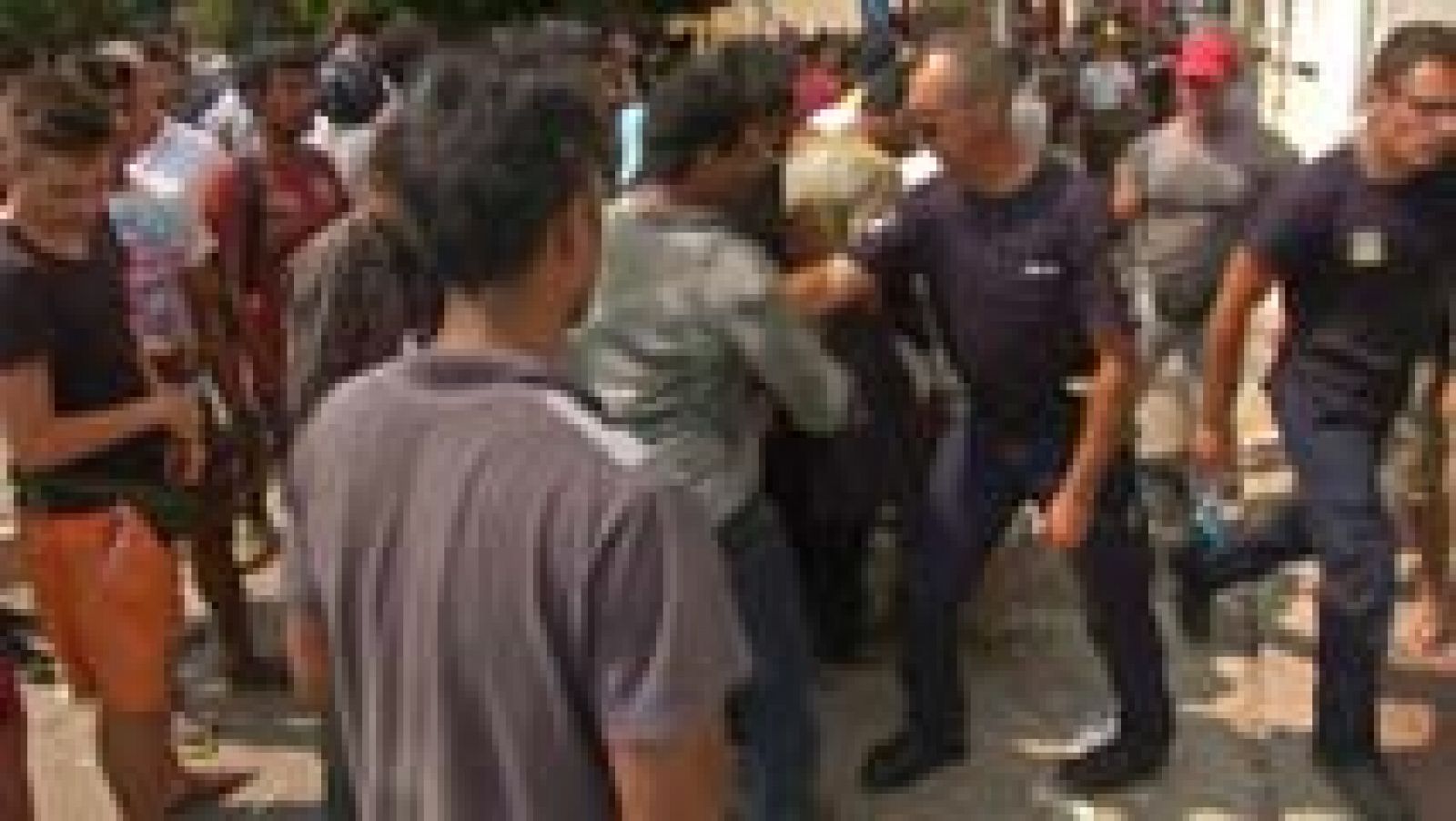 Un policía griego amenaza con un cuchillo a inmigrantes - La tarde en 24h | Ver