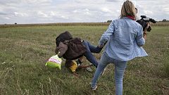 Una periodista húngara zancadilleando a unos refugiados