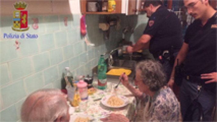 Cuatro policías de Roma reconfortan a una pareja de ancianos solitarios haciéndoles la comida