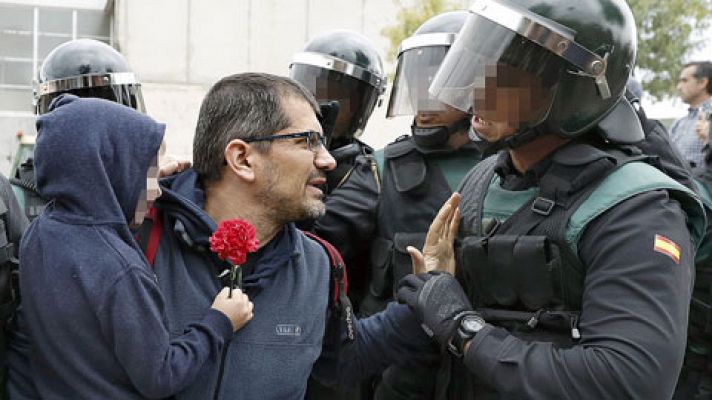 Un agente de la Guardia Civil ayuda a un padre a bajar a su hijo para que no corra peligro