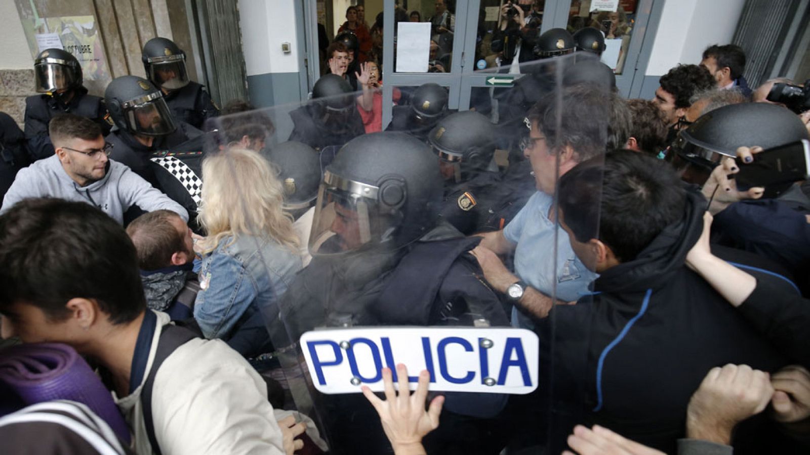 Forcejeos de la Policía Nacional con personas concentradas en la Escola Mediterrània en Barcelona