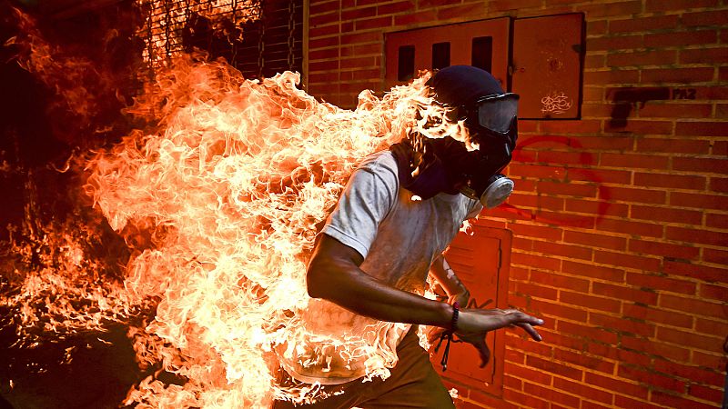 El venezolano Ronaldo Schemidt recibe el World Press Photo por una imagen de unos disturbios en Caracas