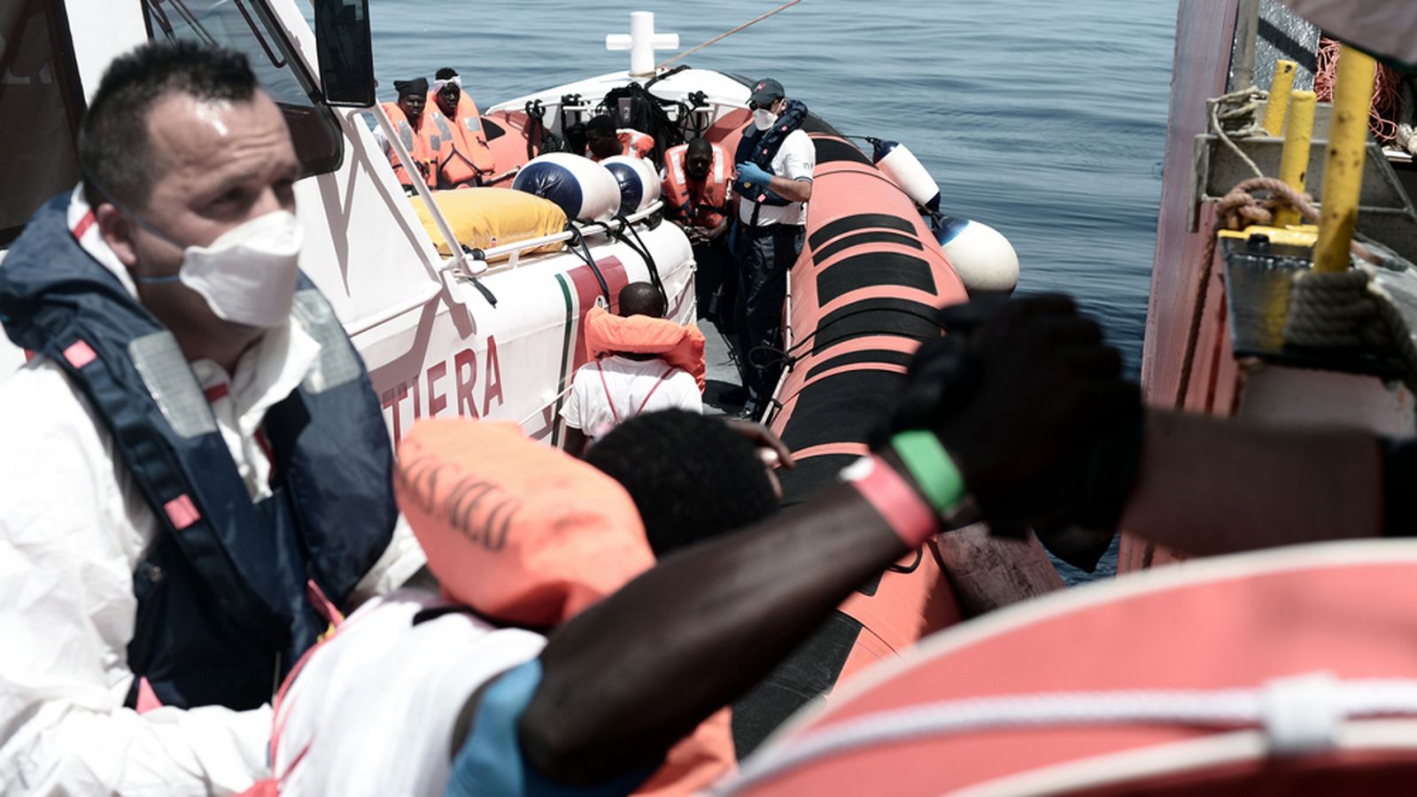 El Aquarius traslada a los migrantes a dos buques militares italianos para viajar a Valencia