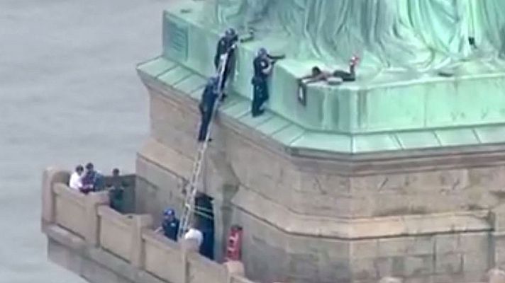 Una activista se sube a la Estatua de la Libertad para protestar por la política de inmigración de Trump