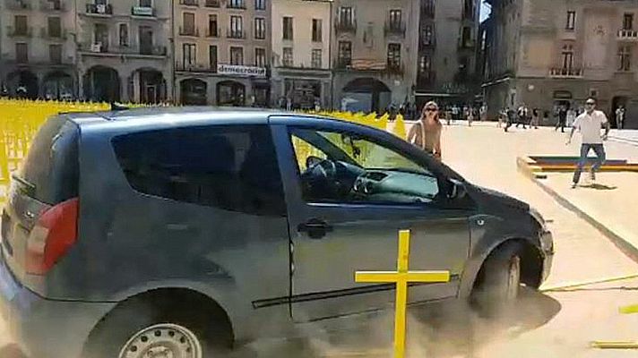 Un coche arrolla varias hileras de cruces amarillas por los presos en la plaza de Vic