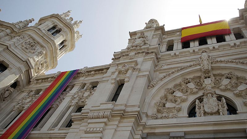El Ayuntamiento de Madrid despliega la bandera LGTBI en un lateral de la fachada y la de España en el centro