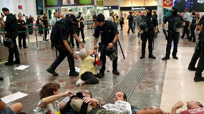 Una mujer se resiste a ser desalojada por los Mossos en la estación de Sants