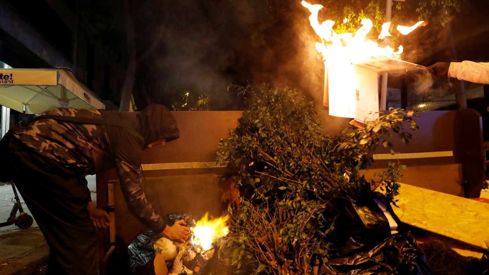 Bomberos dialogan con un grupo de manifestantes para evitar el fuego