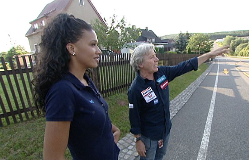 Ángel Nieto le muestra a la periodista de TVE Desirée Ndjambo cómo era el circuito urbano de Sachsenring.