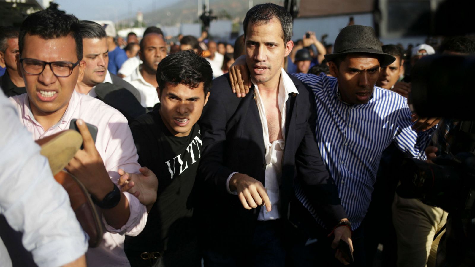 El mandatario, reconocido por más de 50 países, ha regresado a territorio venezolano, donde ha sido recibido por simpatizantes y detractores, que le han propiciado algunos golpes y empujones.
