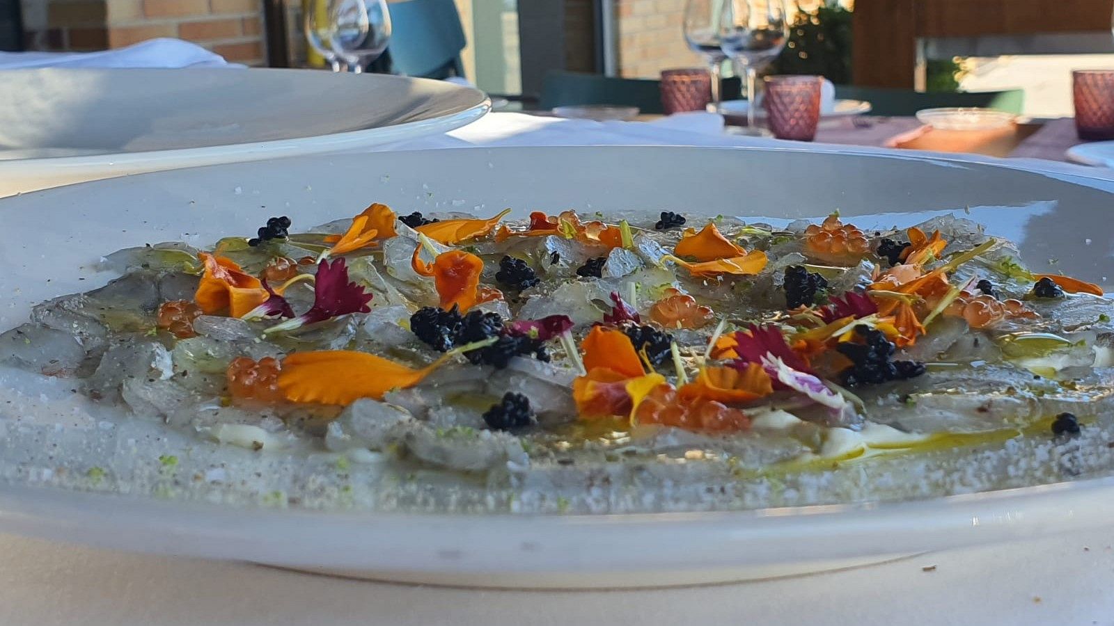 Carpaccio de gambas sobre pil-pil de merluza