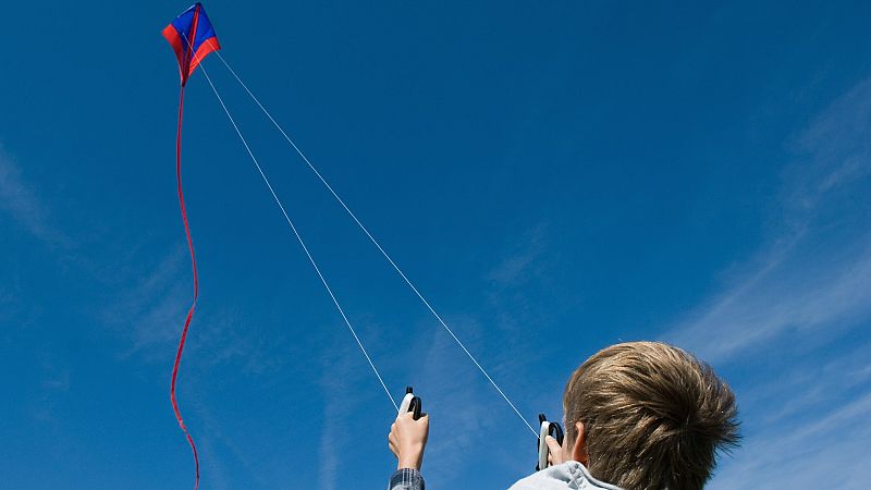 Una ráfaga de viento levanta a una niña junto a su cometa en un festival en Taiwán