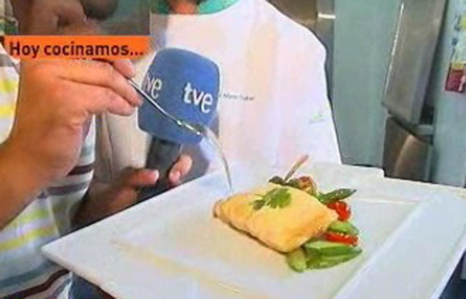 Ingredientes:800 gramos de lubina4 lonchas de tocinoEspárragos verdes1 cebolla12 tomatitos cherryCilantroAceite de olivaSalHostal Reyes CatólicosSantiago de Compostela, A Coruña