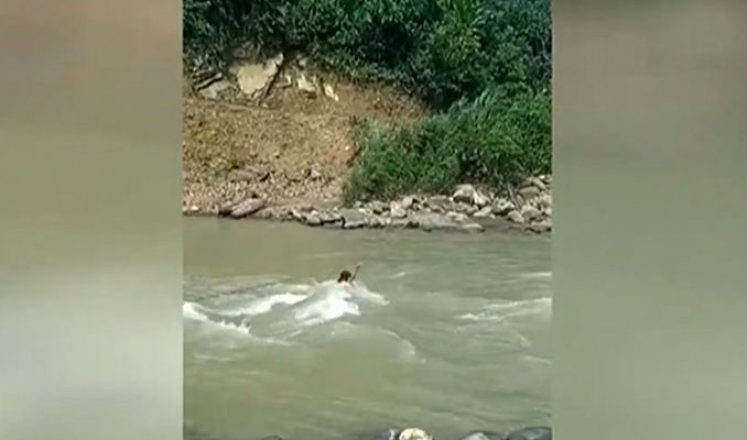 Una niña arriesga su vida por cruzar al otro lado del río en Pueblo Rico, Colombia