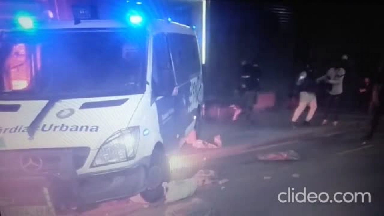 Un grup d'encaputxats cala foc a una furgoneta policial amb un agent a l'interior