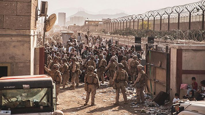 Militares españoles ayudan a afganos a entrar en el aeropuerto de Kabul