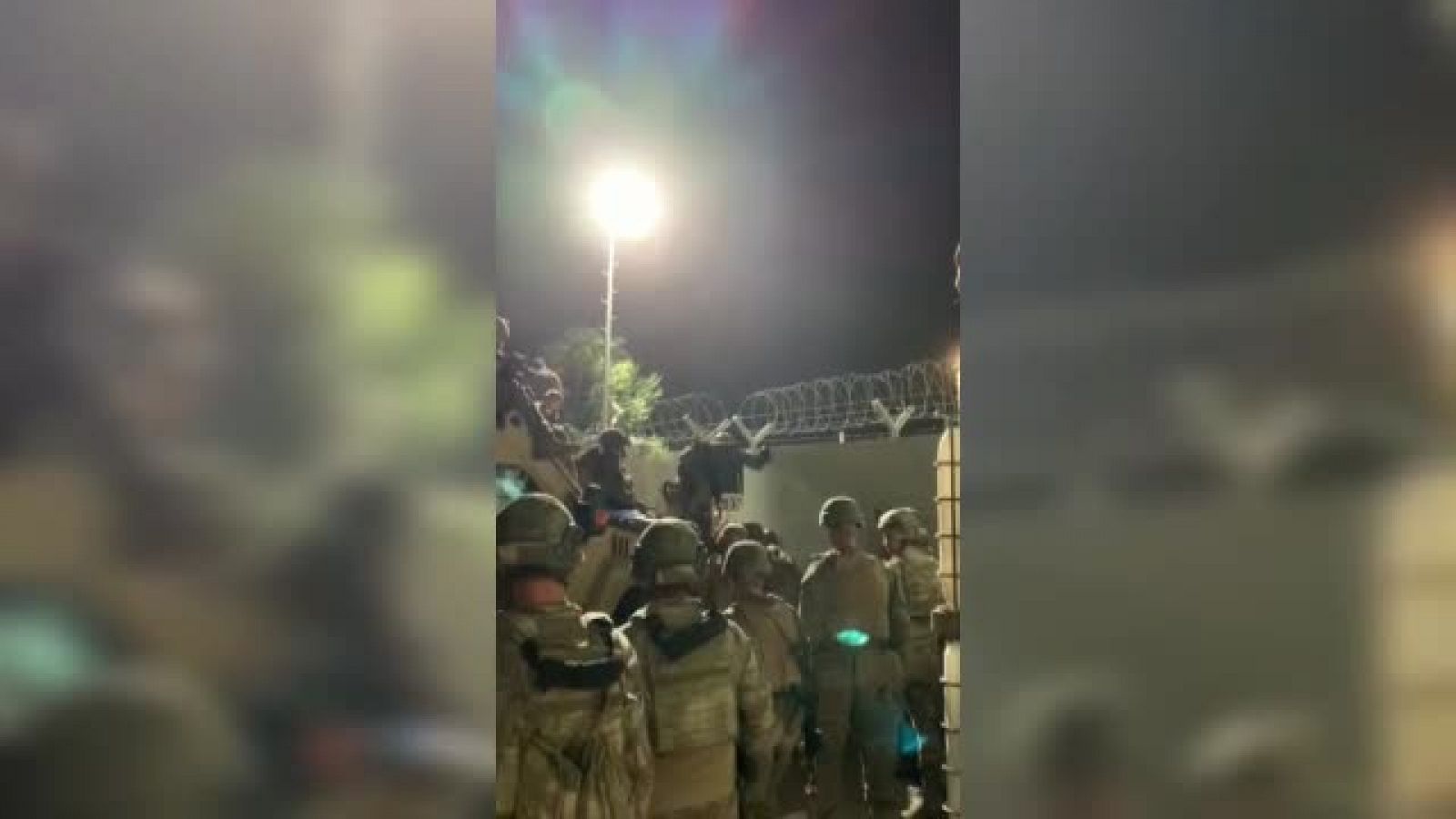 Militares españoles ayudan a afganos a entrar en el aeropuerto de Kabul