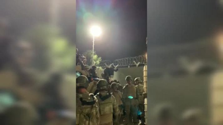  - Militares españoles ayudan a afganos a entrar en el aeropuerto de Kabul