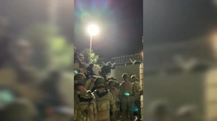 Militares españoles ayudan a afganos a entrar en el aeropuerto de Kabul