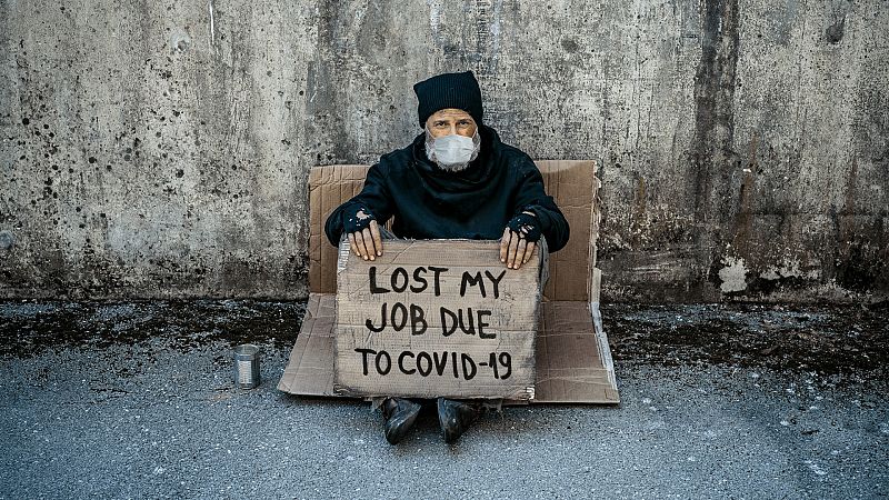 Un hombre sin hogar sostiene un cartel: "Perdí mi trabajo por la covid-19"