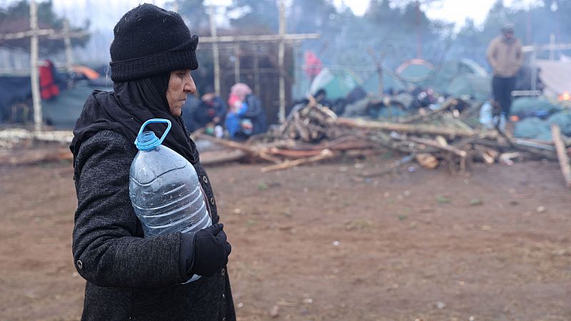Una refugiada lleva una botella de agua vacía