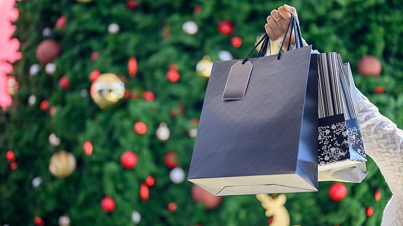 Bolsas de compras junto a un árbol de Navidad