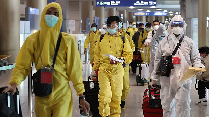 Pasajeros llevando trajes protectores