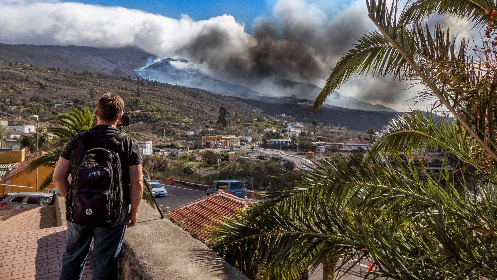 Un hombre con una mochila observando el volcán