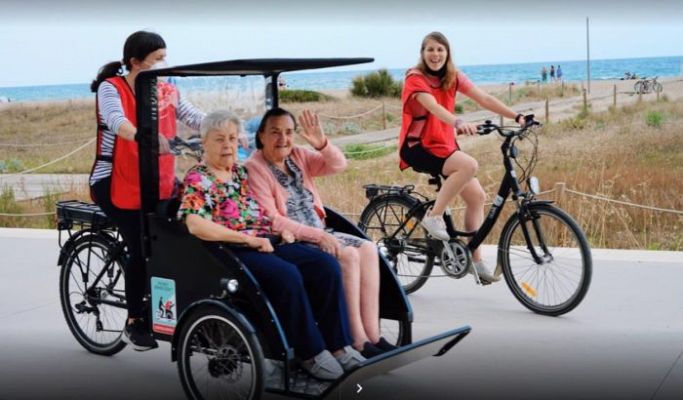 Voluntarios que pasean en triciclo a personas mayores