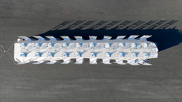 Todos contra 1 - Una mesa con vajilla, el mantel atado a un coche de carreras