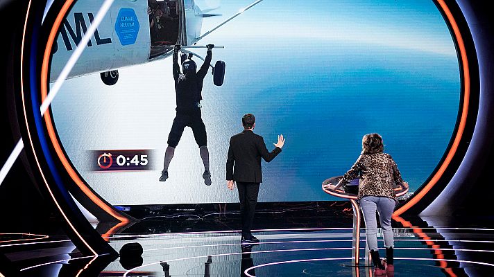  - El hombre pájaro sujeto de una barra aguanta suspendido