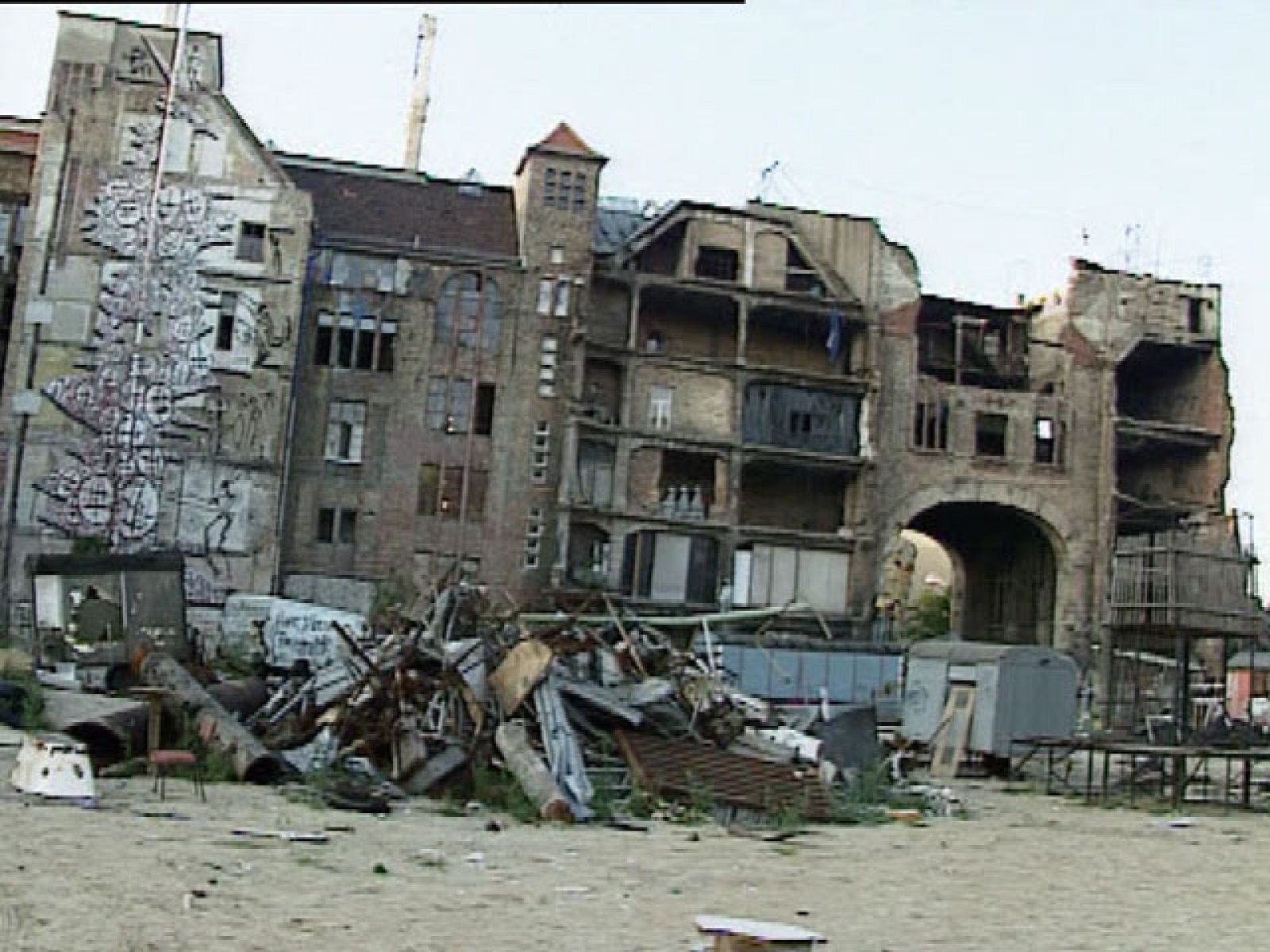 Desde hace 20 años, la casa okupa Tacheles es uno de los símbolos culturales y turísticos de Berlín. Quizá dentro de unos días puede que sólo sea un recuerdo.  Se da la paradoja de que un banco se ha quedado con los terrenos que hasta ahora ocupaban unos 60 artistas alternativos y esta semana empieza a desalojar a los artistas. Alrededor de Tacheles muchos negocios viven de los 400.000 turistas al año que visitan la casa okupa. Después de la puerta de Brandemburgo, dicen que es lo más conocido de Berlín. Aunque los artistas lucharán hasta el final para evitar que se cierre uno de los símbolos de Berlín.