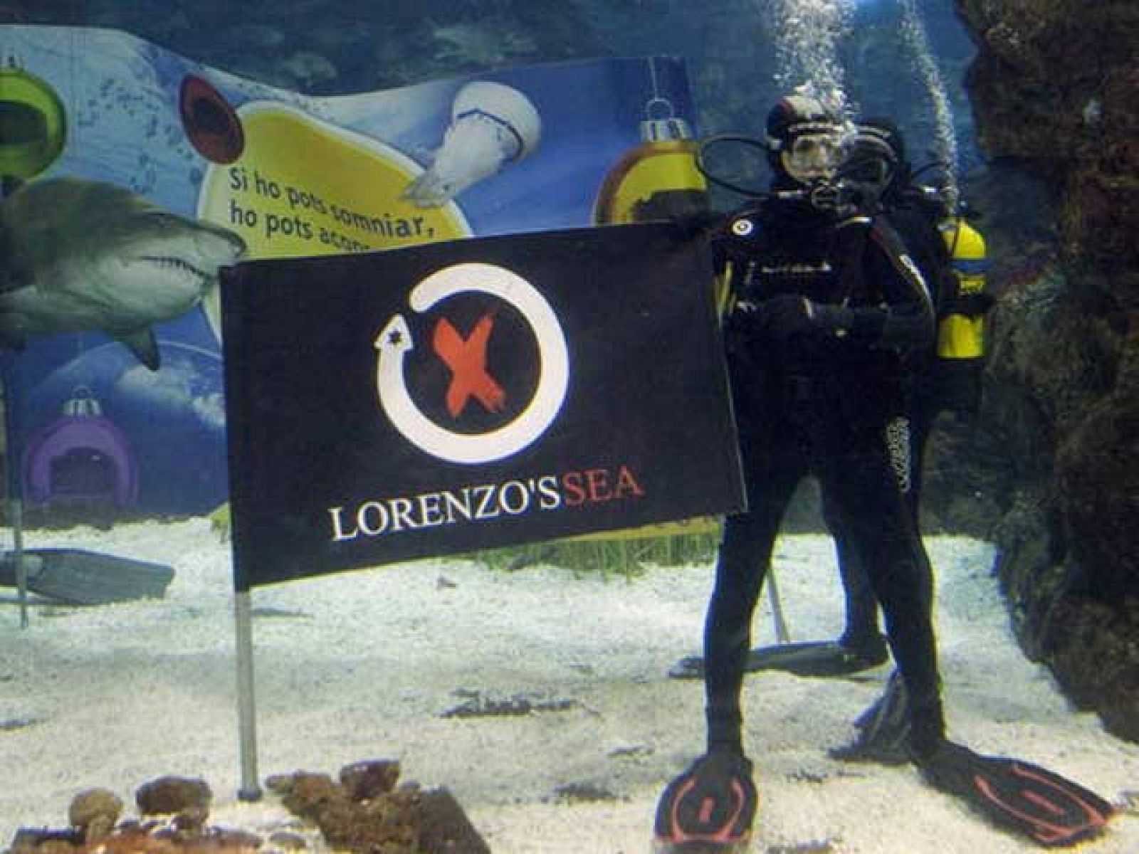 El campeón de MotoGP, Jorge Lorenzo, ha querido felicitar las fiestas navideñas de un modo muy especial: se ha sumergido junto a los tiburones del 'Aquarium' de Barcelona.